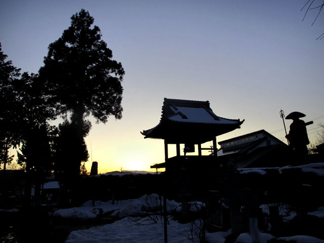 お寺の鐘と夕日の光